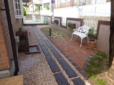 こちらのお庭の通路部には枕木調のコンクリート平板にておもてなし、レンガにてステージ・花壇の粋な演出を提案しました。