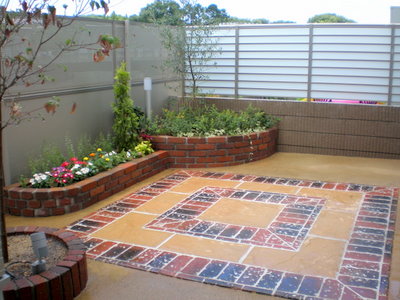 裏庭には、スクエア型のステージを作り・・・ 土を残す部分はレンガで花壇を制作しました。